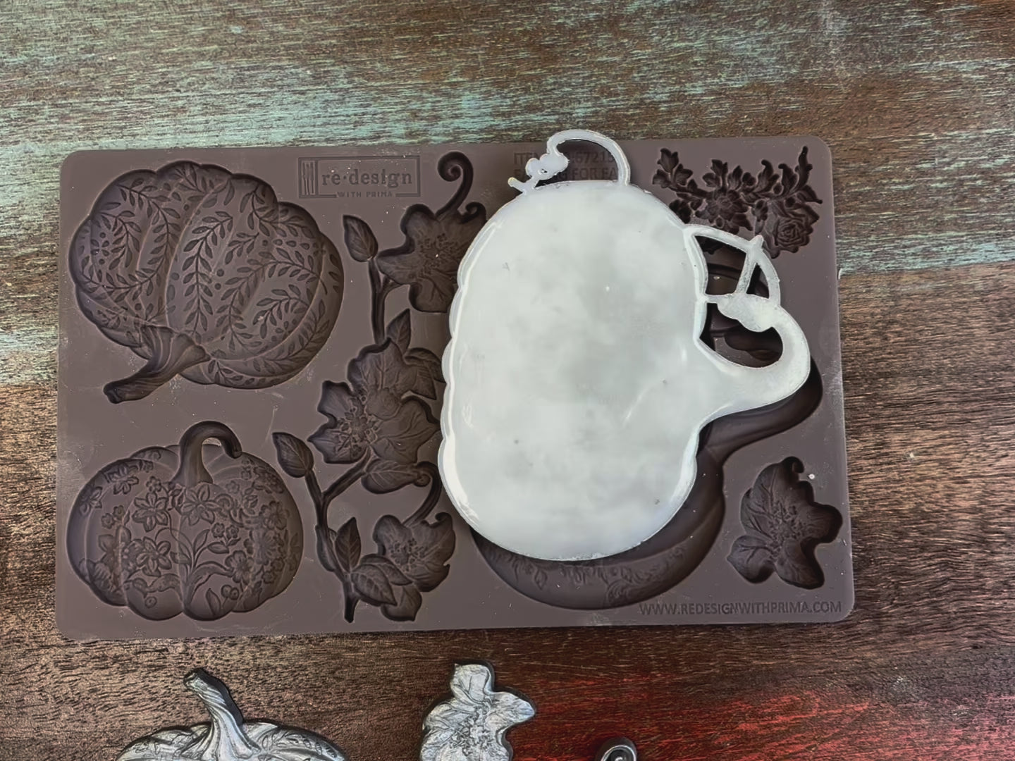 A 12 second video shows close-ups of ReDesign with Prima's Falling for Fall silicone mold and silver colored castings. A hand is shown picking up and holding the silicone mold and a casting.