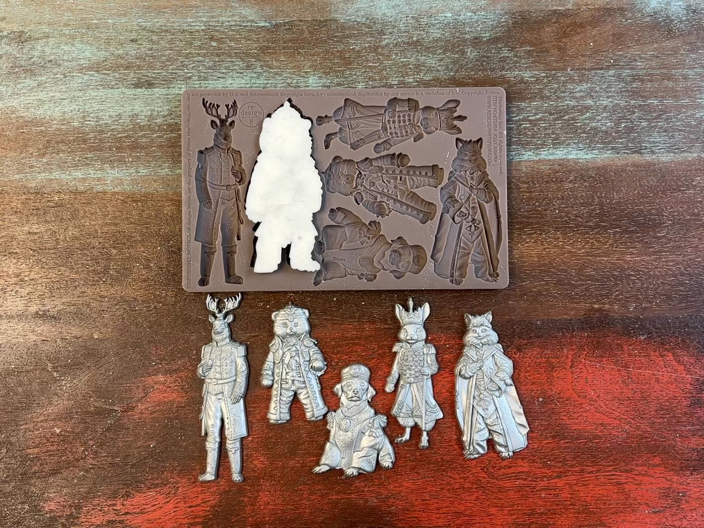 A 15 second video shows a close-up ReDesign with Prima's Jolly Jumper silicone mold and silver colored castings. A hand is shown holding one of the castings.