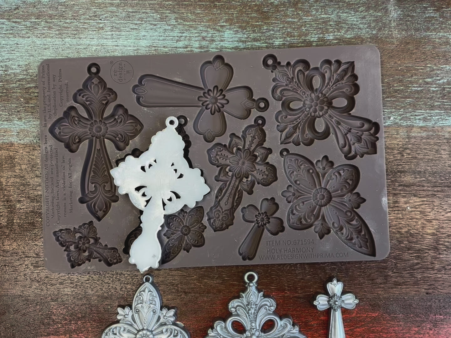 A 14 second video shows close-ups of ReDesign with Prima's Holy Harmony silicone mold and silver colored castings. A hand is shown lifting and holding the mold and a casting.