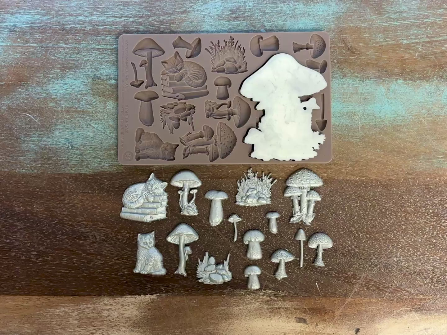 A 15 second video shows a close-up of Prima Marketing's Fairyland Fungi silicone mold and silver colored castings. A hand is shown picking up the fairy mushroom house casting.