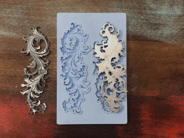 A 14 second video shows a hand picking up LaBlanche's Curved Ornament silicone mold and a silver colored casting.