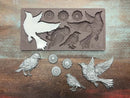 A 13 second video shows a close-up of ReDesign with Prima's Gears of Flight silicone mold and silver colored castings against a wood background. A hand is shown picking up one of the bird castings.