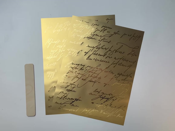 A 14 second video shows a close-up and backside of ReDesign with Prima's Kacha Shimmering Script gold foil small rub-on transfers against a white background.