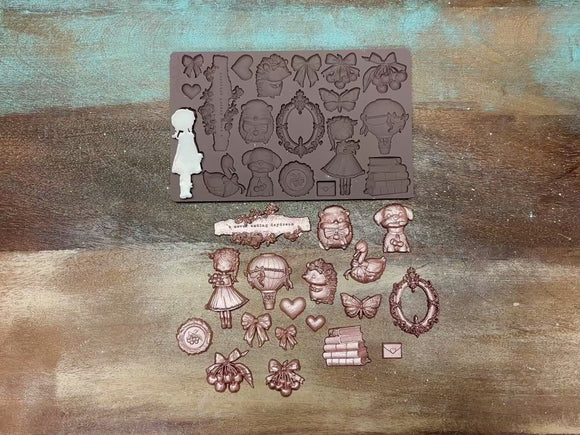 A 14 second video shows a close-up of Prima Marketing Cherry Sweet silicone mold and gold colored castings against a wood background. 