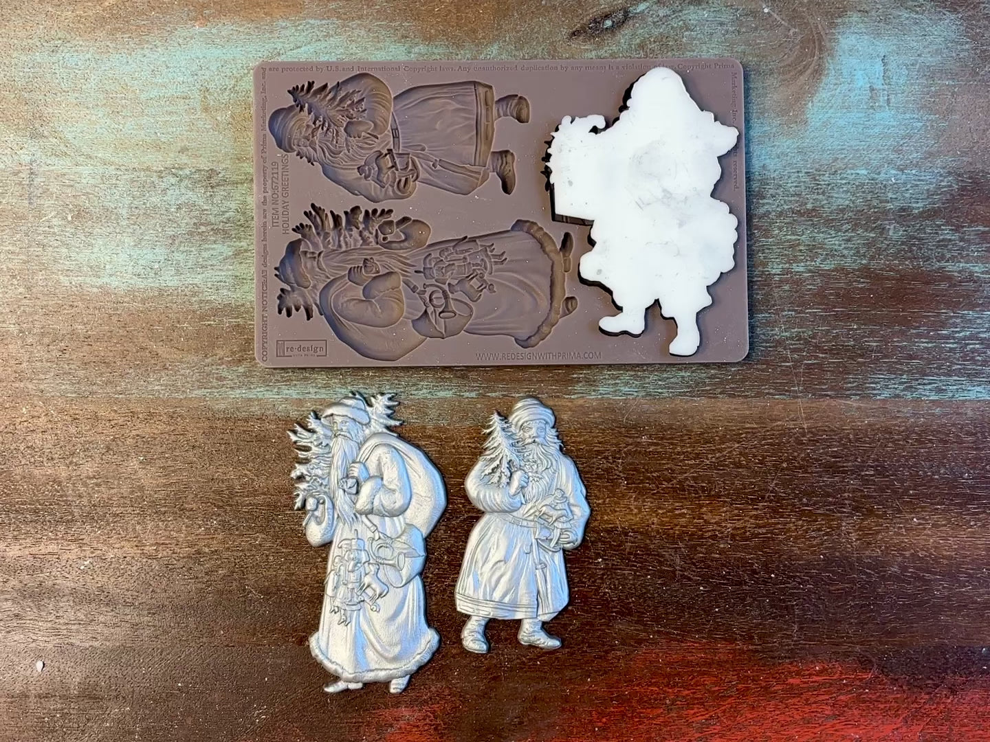 A 13 second video shows a close-up ReDesign with Prima's Holiday Greetings silicone mold and silver colored castings. A hand is shown holding one of the castings.