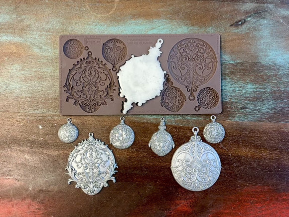 A 14 second video shows a close-up ReDesign with Prima's Vintage Glamour silicone mold and silver colored castings. A hand is shown holding one of the castings.