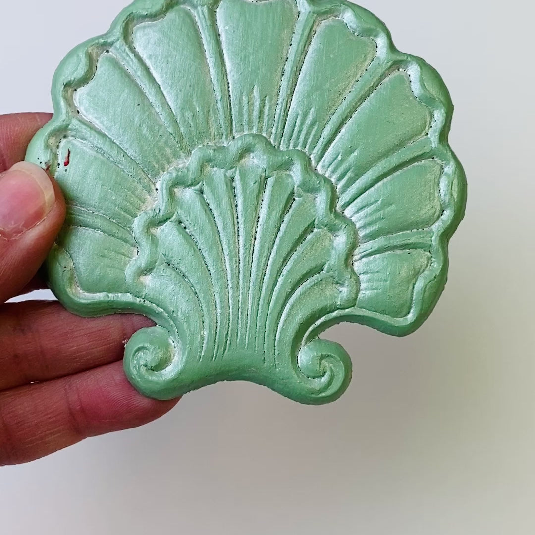 A 7 second video is shown holding a mint green shell shaped flower silicone mold casting that has been detailed with Dixie Belle's Pearlescent Glaze.