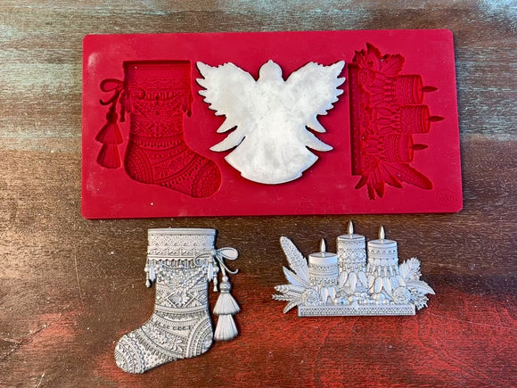 A 14 second video of Zuri Design's Bohemian Christmas Decor silicone mold and silver colored castings are against a wood background. A hand is shown holding the angel casting.
