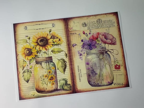 A 14 second video shows a close-up and a hand lifting and folding the top left corner of Decoupage Queen's Flowers in Mason Jar 4 against a white background.