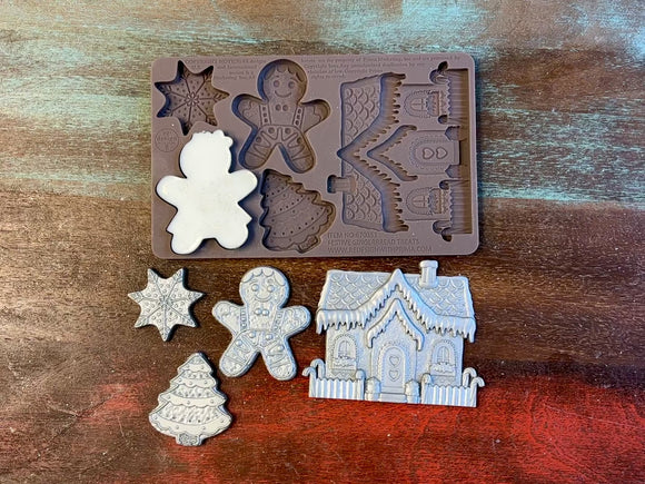 A 13 second video shows a close-up ReDesign with Prima's Festive Gingerbread Treats silicone mold and silver colored castings. A hand is shown holding one of the castings.