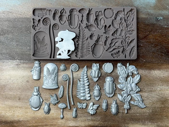 A 14 second video shows a close-up of ReDesign with Prima's Midnight Muses silicone mold and silver colored castings against a wood background. A hand is shown picking up and holding the cluster of mushrooms casting.