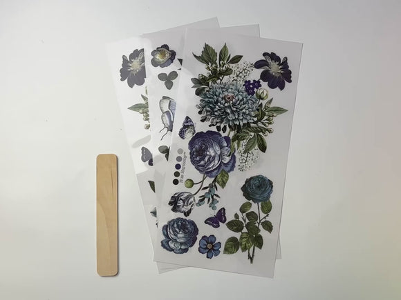 A 15 second video shows a close-up of 3 sheets of ReDesign with Prima's Indigo Petals small rub-on transfers against a white background.