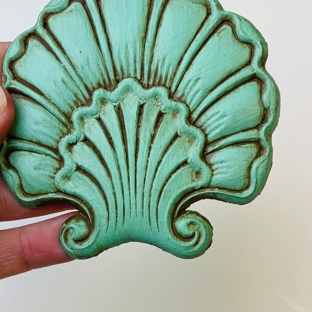 A 7 second video is shown holding a mint green shell shaped flower silicone mold casting that has been detailed with Dixie Belle's Van Dyke Brown Glaze.