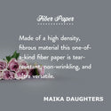 A gray background with a bouquet of roses. White text is shown reading: Fiber paper. Made of a high density, fibrous material this one-of-a-kind fiber paper is tear-resistant, non-wrinkling, and ultra versatile. Maikadaughters.com