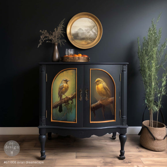 A vintage bar cabinet is painted dark blue and features ReDesign with Prima's Avian Dreamscape tissue paper on its 2 door inlays with gold trim.