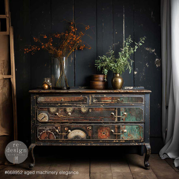 A vintage dresser is painted a weathered black and features ReDesign with Prima's Aged Machinery Elegance A1 fiber paper on its 4 drawers.