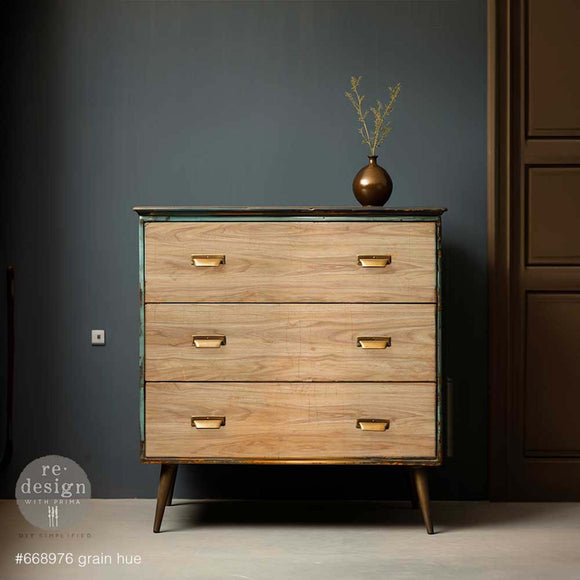 A mid-century dresser is painted a rusty patina green and features ReDesign with Prima's Grain Hue A1 fiber paper on its 3 drawers.