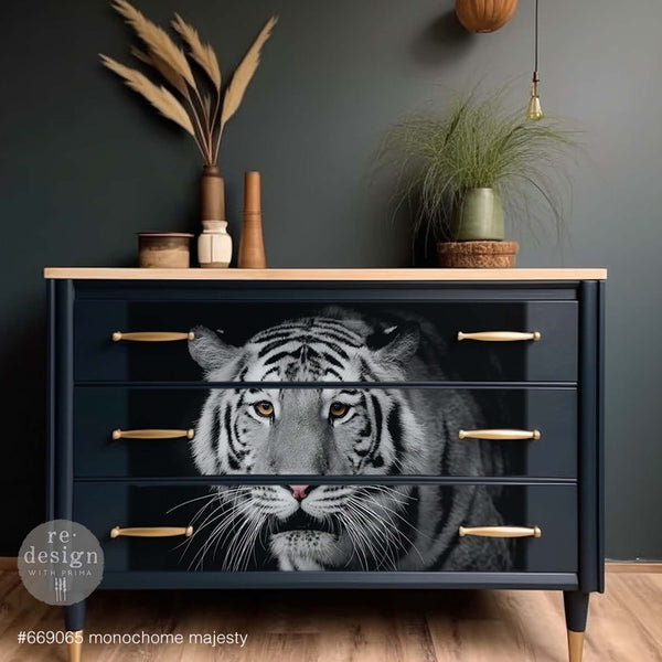 A mid-century style dresser is painted midnight blue with gold accents and features ReDesign with Prima's Monochrome Majesty in the center of its 3 large drawers.