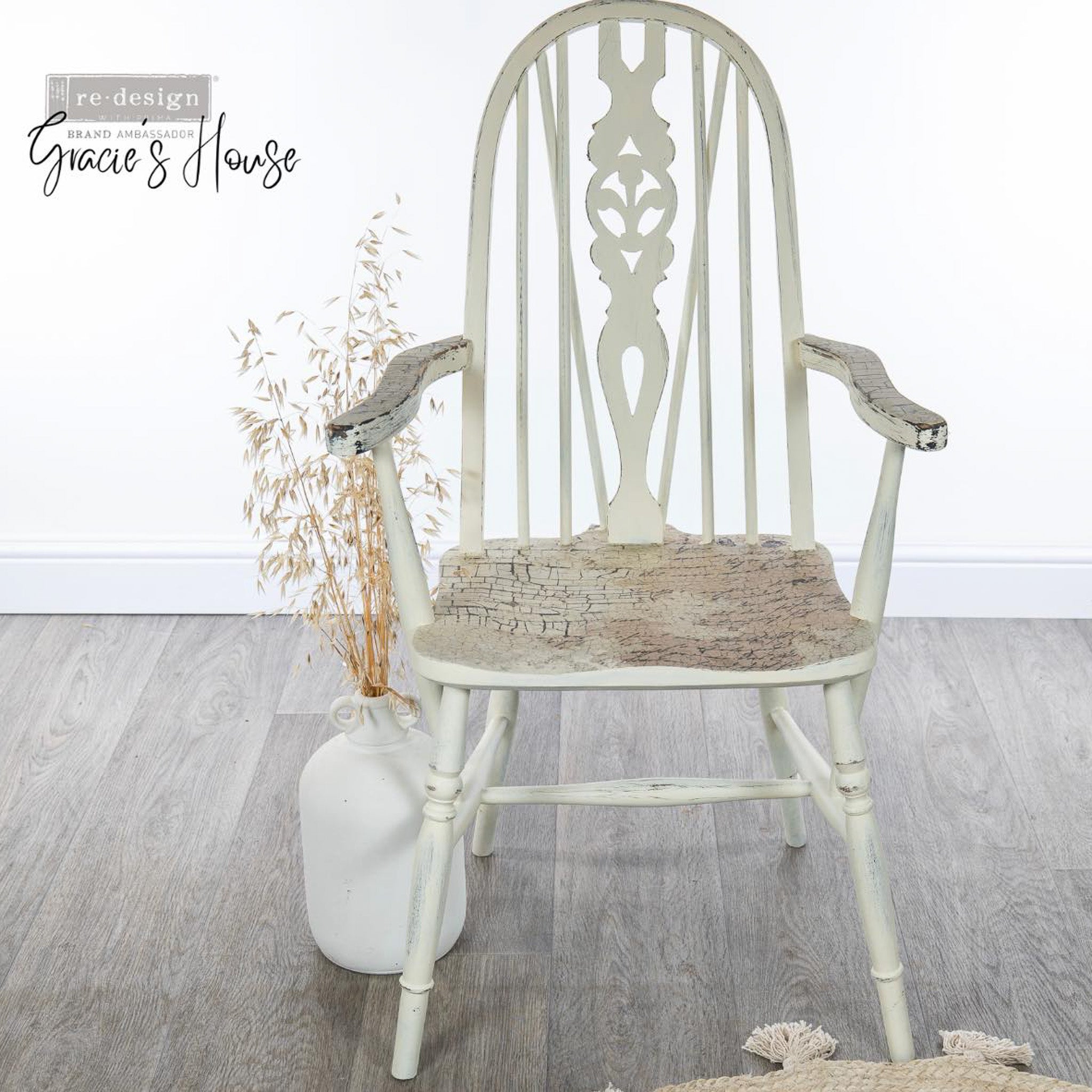 A vintage wood chair refurbished by Gracie's House is painted white and features ReDesign with Prima's La Spaccatura on the seat and arm rests.