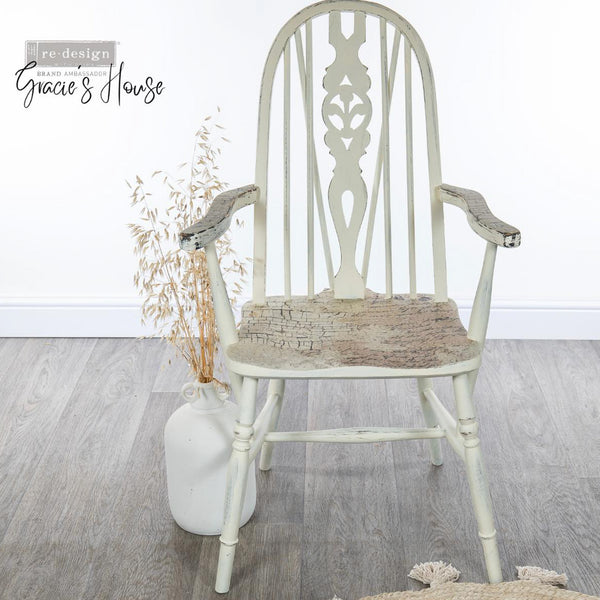 A vintage wood chair refurbished by Gracie's House is painted white and features ReDesign with Prima's La Spaccatura on the seat and arm rests.