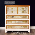A 7-drawer chest dresser refurbished by Calle's ReDesigns is painted white with natural wood accents and features ReDesign with Prima's La Spaccatura tissue paper on its drawer inlays.