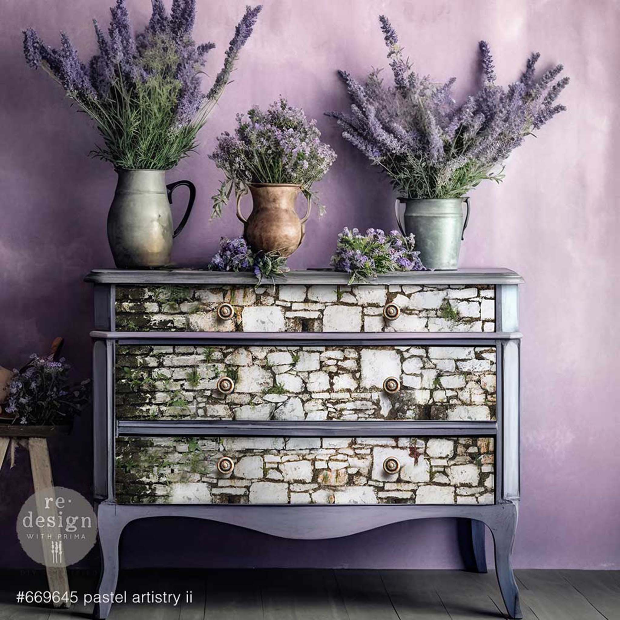 A vintage 3-drawer dresser is painted lavender and features ReDesign with Prima's Pastels Artistry 2 on the drawers.