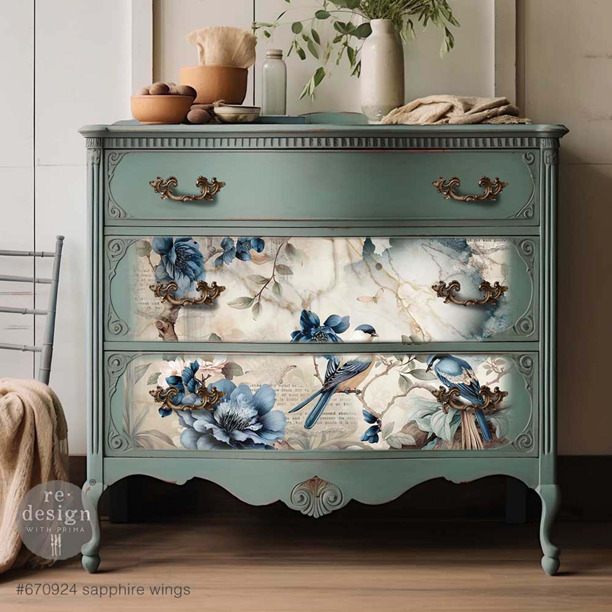 A vintage 3-drawer dresser is painted a muted teal blue and features ReDesign with Prima's Sapphire Wings tissue paper on the bottom 2 drawers.