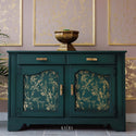 A dark teal buffet table with gold handles refurbished by Kacha features A Bird Song on its doors.