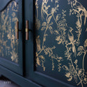 Close-up of a dark teal buffet refurbished by Kacha features A Bird Song on its doors.