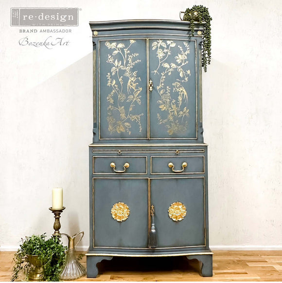 A tall armoir refurbished by Bozenka Art, a ReDesign Brand Ambasador, is painted a grey-blue and features A Bird Song on its doors.