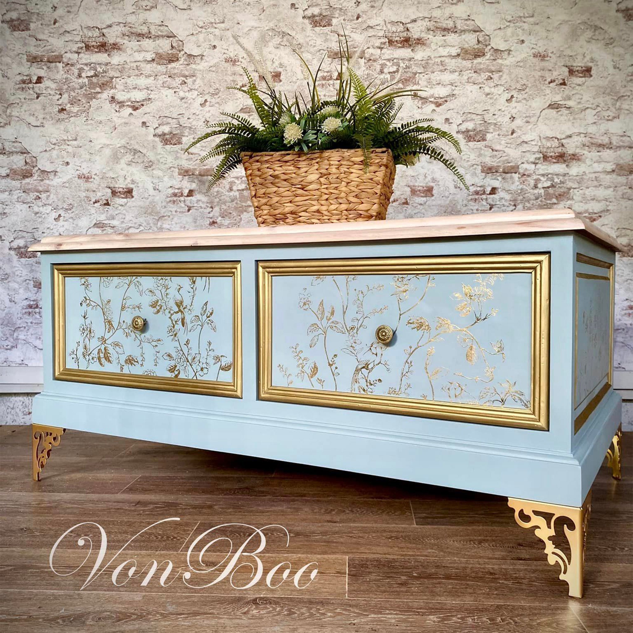 A vintage console table with 2 drawers refurbished by Von Boo is painted pale blue with gold accents and features ReDesign with Prima's Kacha A Bird Song Gold Foil rub on transfer on the drawers.