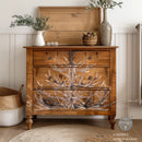 A 4-drawer chest dresser is stained natural wood and features ReDesign with Prima's Antler Chandelier transfer on the front.