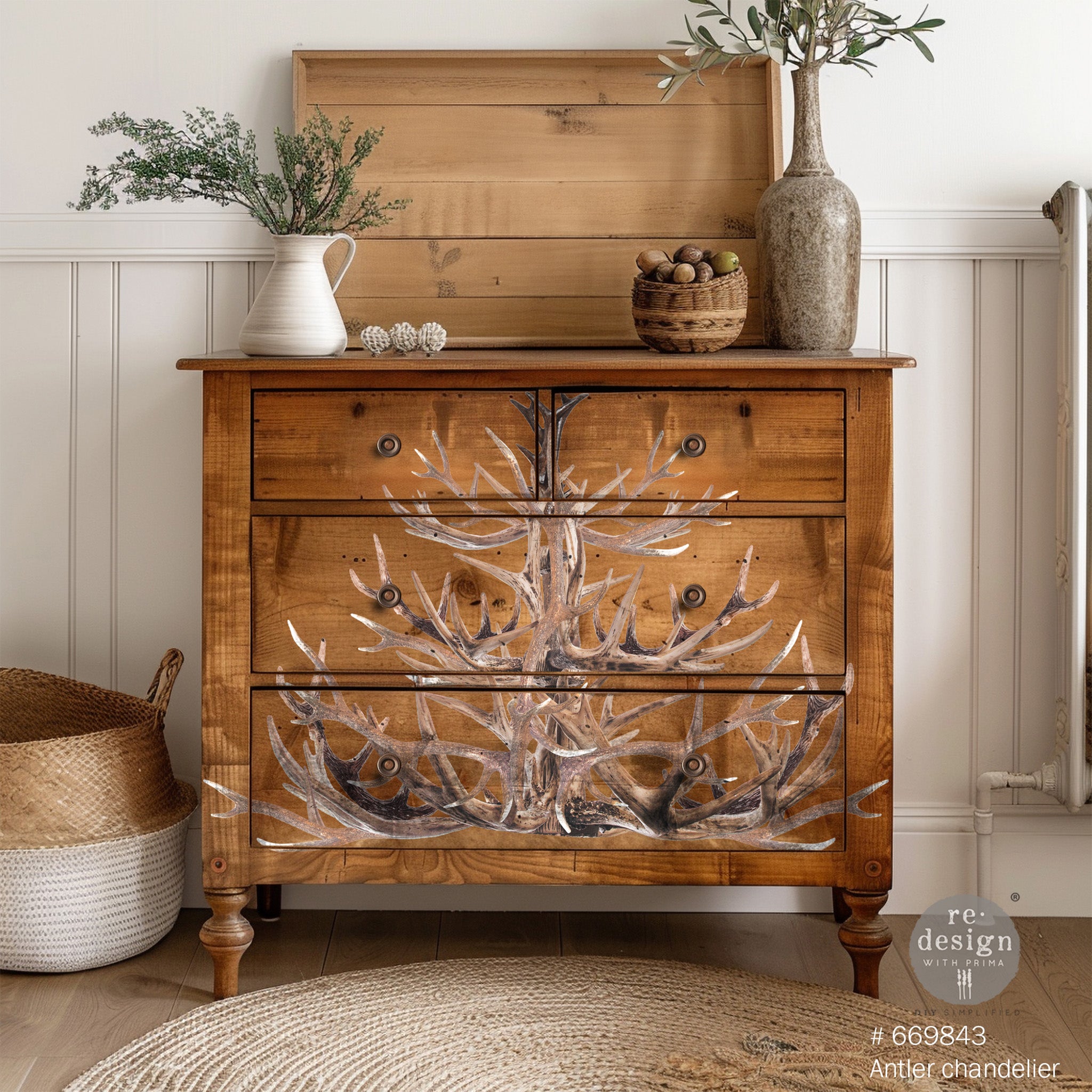 A 4-drawer chest dresser is stained natural wood and features ReDesign with Prima's Antler Chandelier transfer on the front.