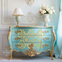 A vintage Bombay style dresser refurbished by ReDesign with Prima is painted a sky blue with gold accents and features House of Damask on its drawers.