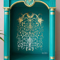 A close-up of a teal and gold open side table refurbished by Kacha features Manor Swirls inside the backboard.