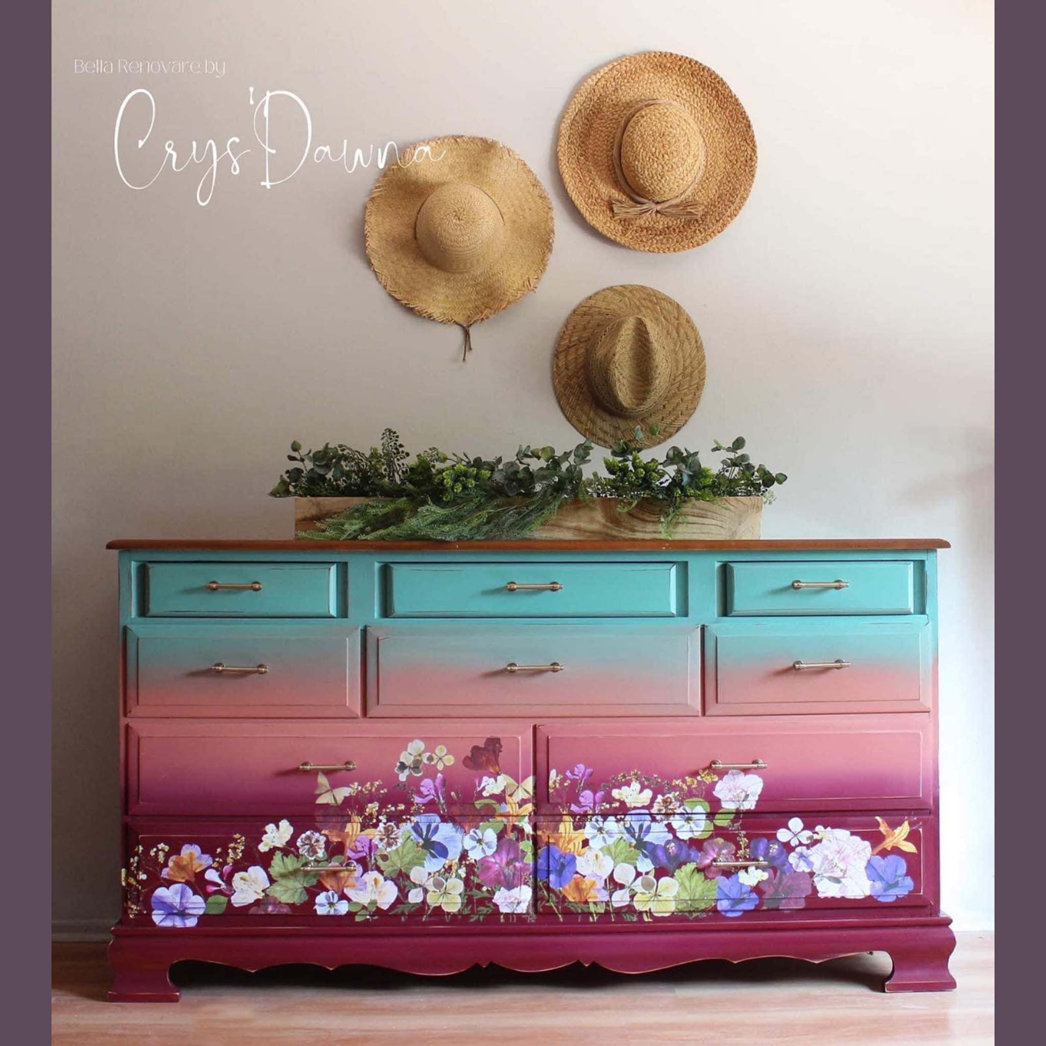 A vintage large 10drawer dresser refurbished by Crys'Dawna is painted an ombre blend of light teal, coral pink, and magenta and features ReDesign with Prima's Pressed Flowers transfer on the bottom 4 drawers.