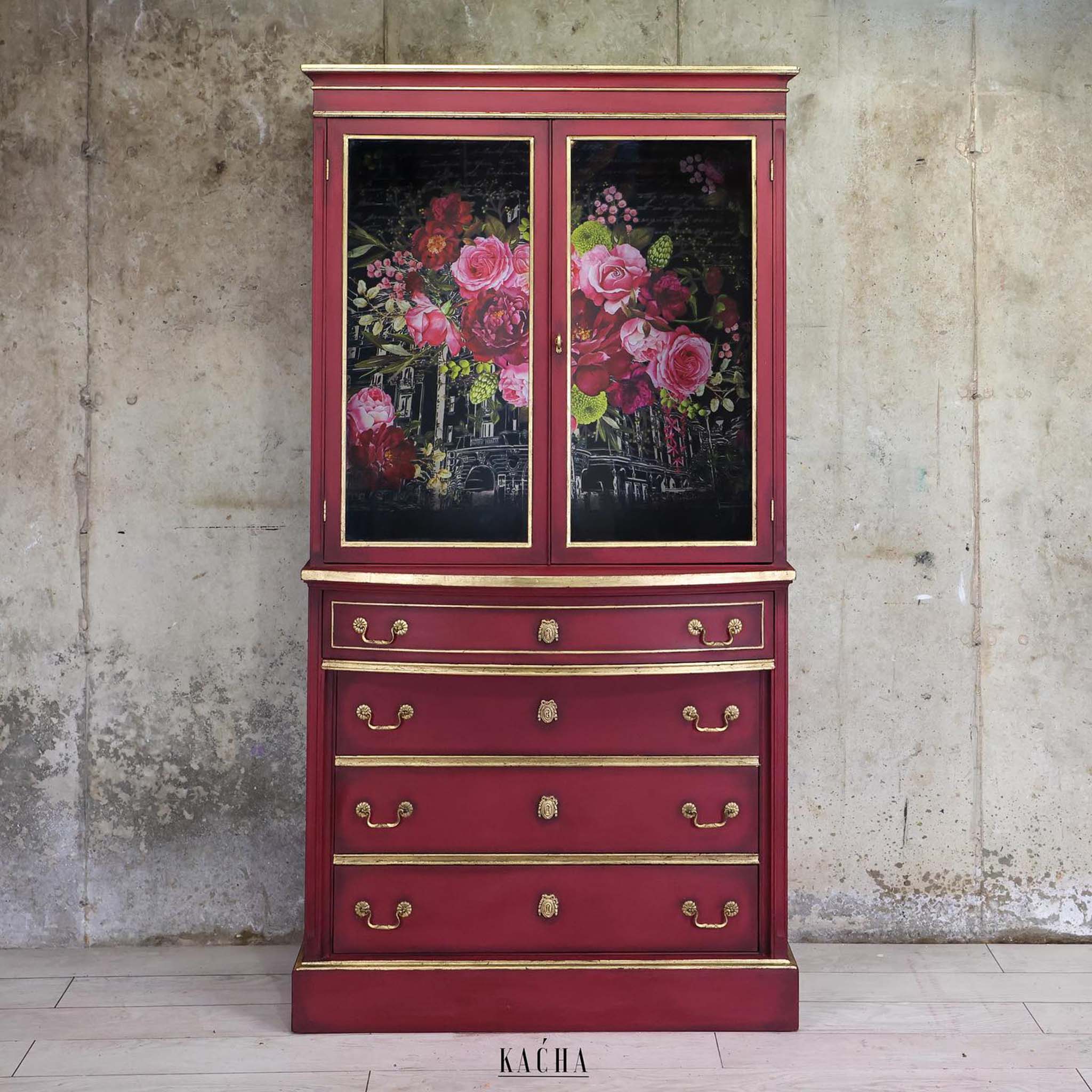 A vintage armoire refurbished by Kacha is painted dark red with gold accents and features ReDesign with Prima's Royal Burgundy transfer on its doors.