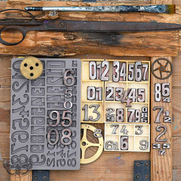 Vintage-style letterpress type and numbers on a wooden background with tools.