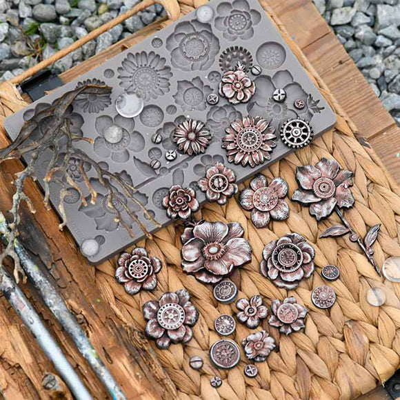 Metal flower-shaped mold on a wooden surface with metal flowers around it.