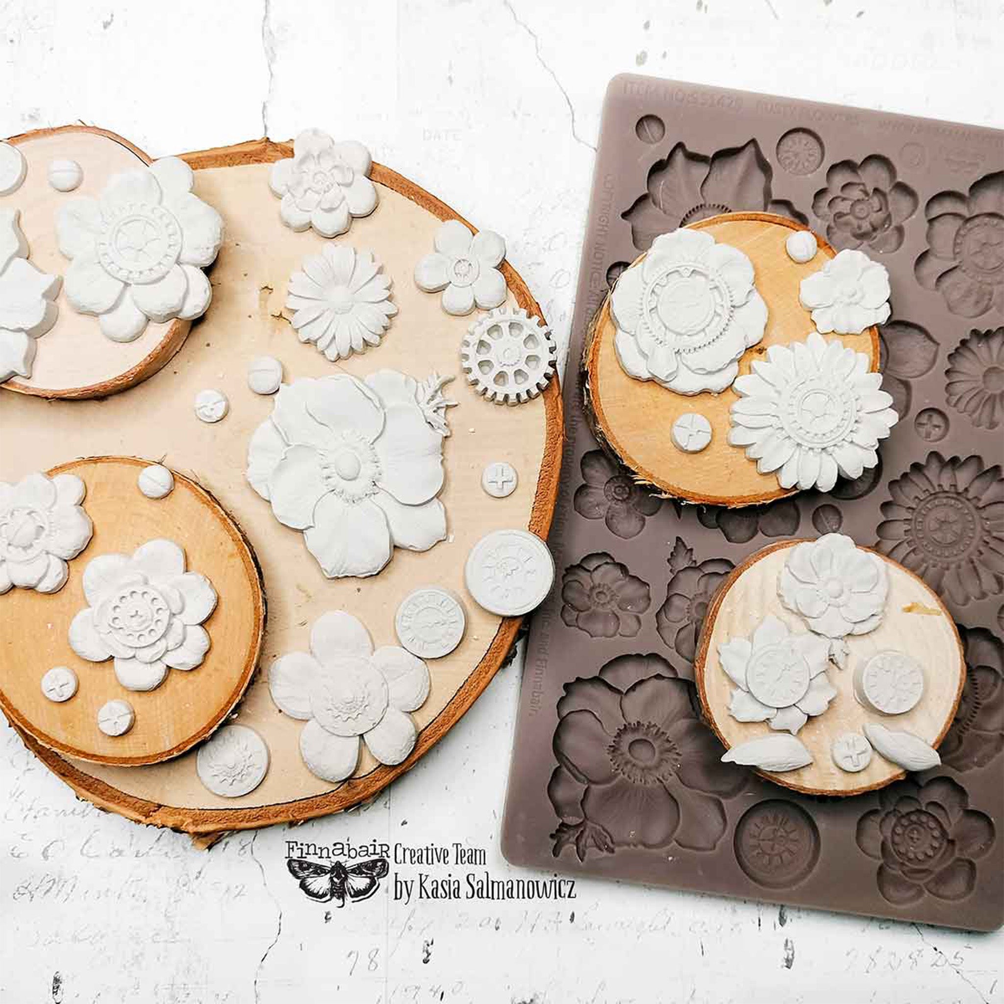 Decorative white casting with floral designs next to a silicone mold on a white background