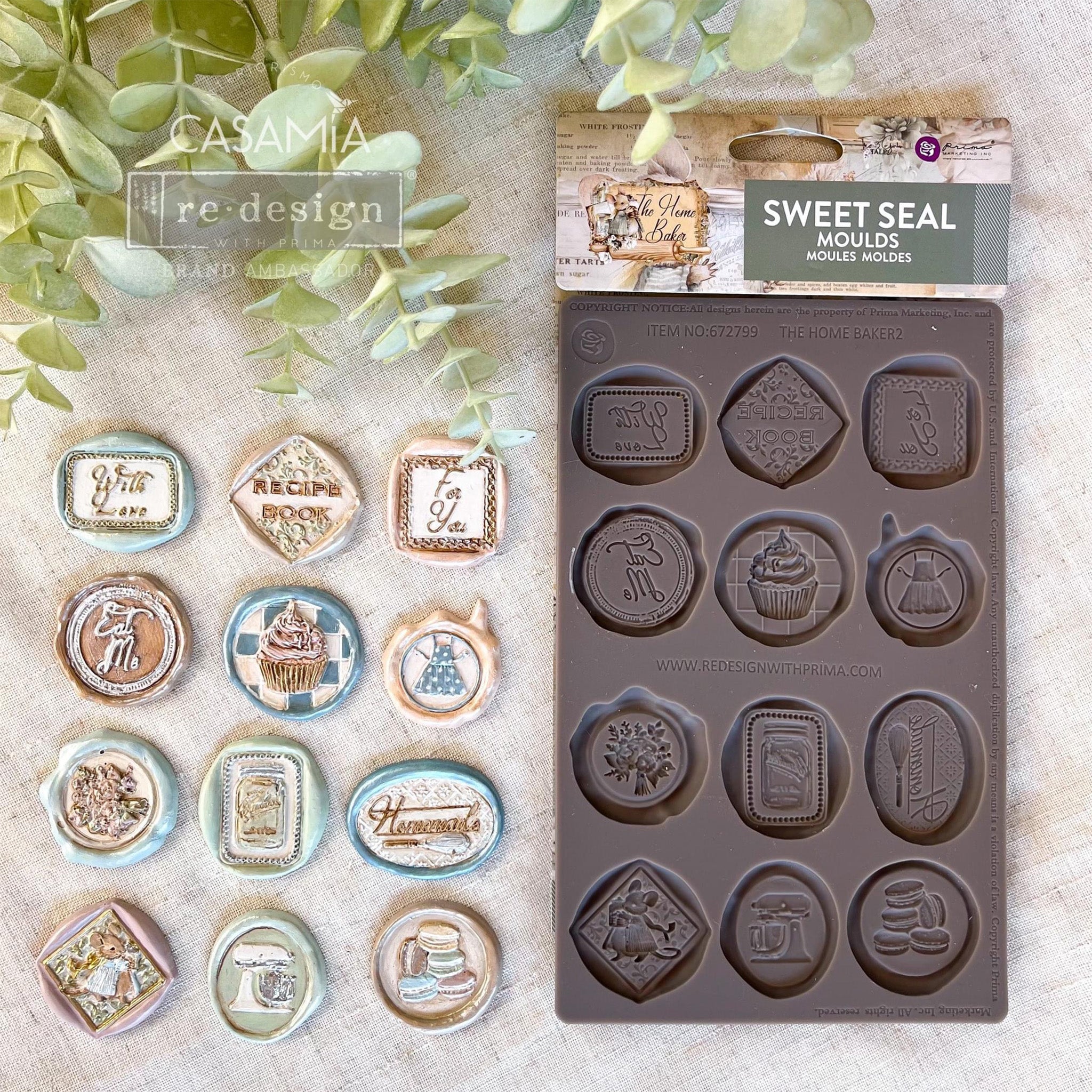 A brown silicone mold and colorful castings of 12 baking themed wax seals are against a linen background.