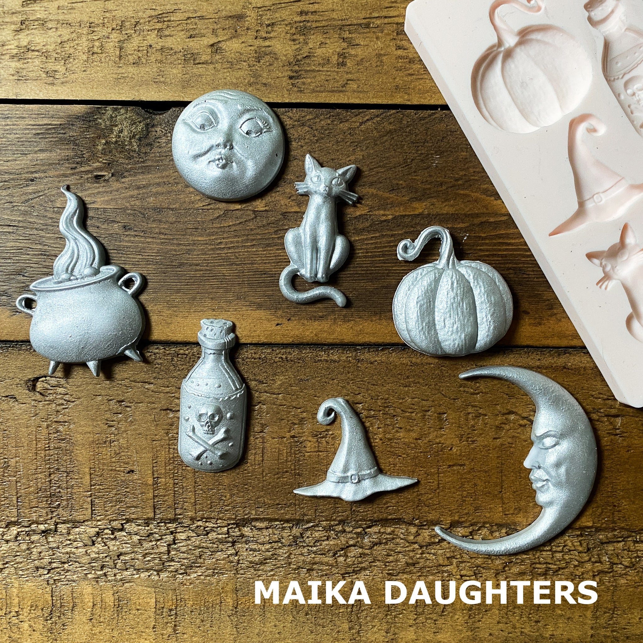 Silver colored silicone mold castings from Prima Marketing's Luna are against a wood background.