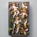 Decorative mold with angel figures and floral elements on a textured background