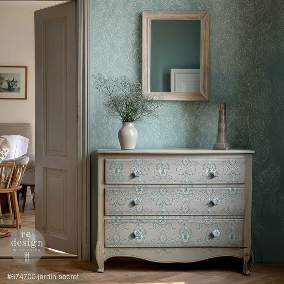 ReDesign with Prima Jardin Secret furniture transfer on a soft neutral dresser with pale blue-green French toile pattern, cottagecore decor, and botanical wall details.