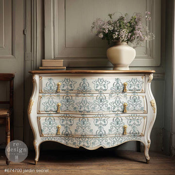 ReDesign with Prima Jardin Secret rub-on furniture transfer on a cream bombe dresser with sage green French toile medallions, ornate gold details, and vintage brass hardware.
