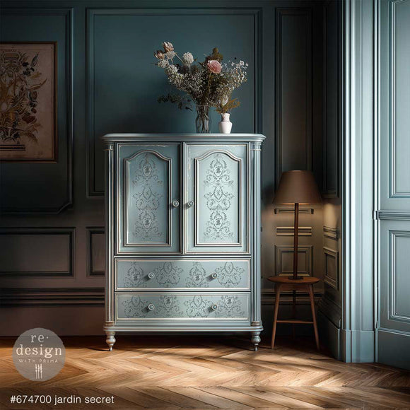 ReDesign with Prima Jardin Secret furniture transfer applied to a pale blue armoire with cabinet doors and drawers in a moody French country room.