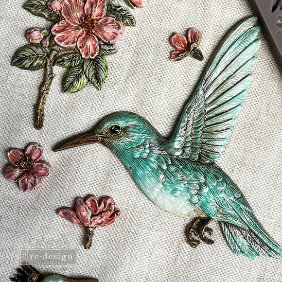 Close-up of painted hummingbird and floral castings made with ReDesign with Prima Bloom & Flutter silicone mold