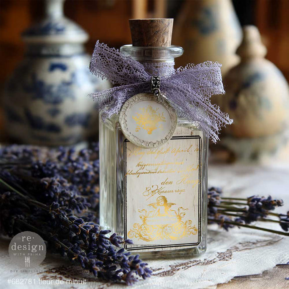 Glass bottle decorated with Fleur de Minuit gold water slide transfer label, lavender ribbon, and vintage French decor styling
