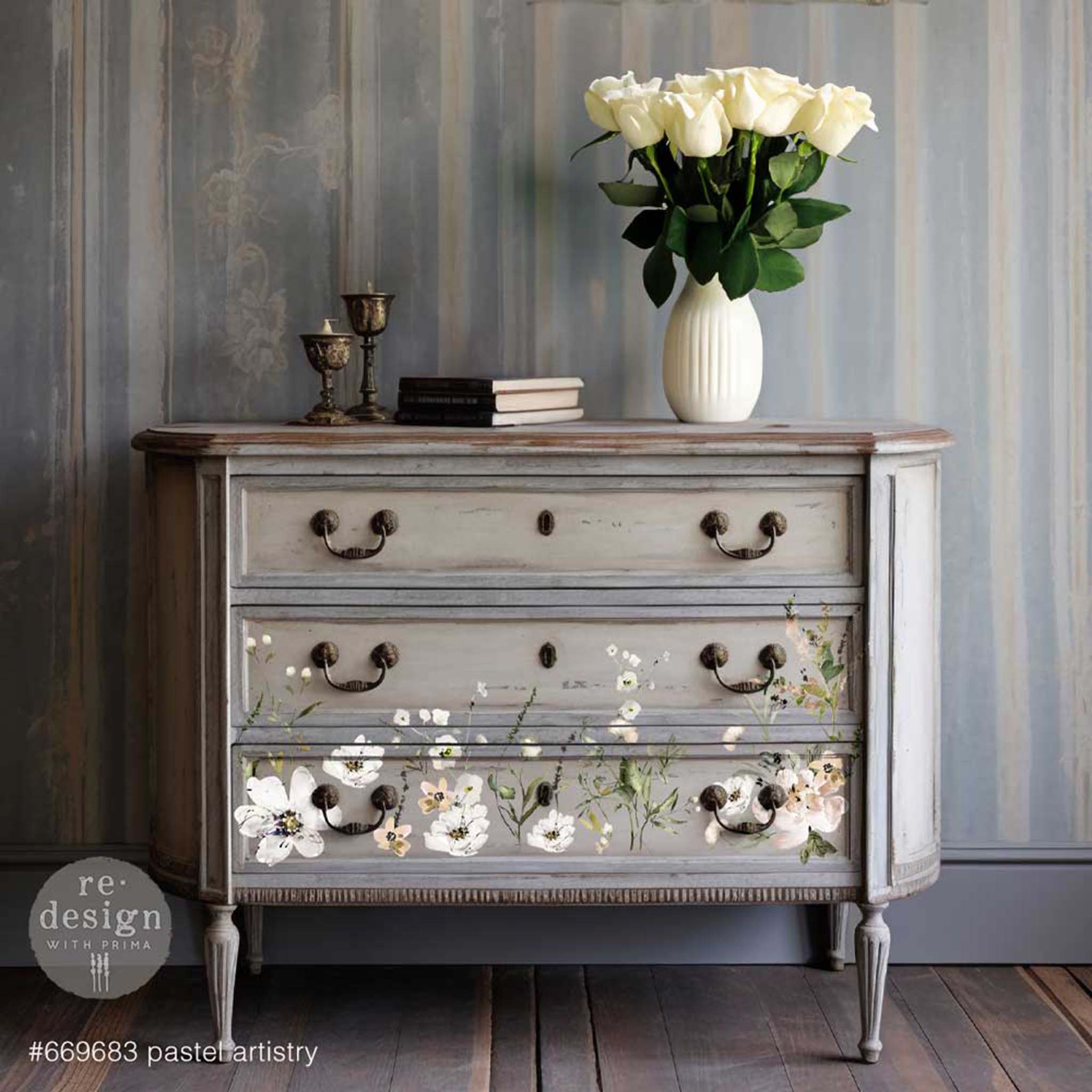 A vintage 3-drawer dresser is stained a light gray and features ReDesign with Prima's Pastels Artistry 12"x12" transfer on the bottom 2 drawers.