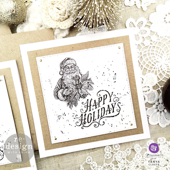 A square corkboard decor created by Tanya Cloete features stamps of Santa and the word Happy Holidays created by using ReDesign with Prima's Santas Helper Tags clear decor stamps.